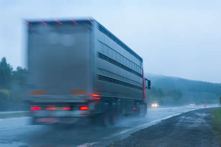 truck going on the wet country highway to rainの写真素材