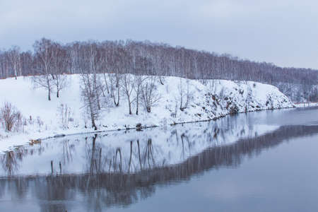 beautiful snow-covered river bank in winterの写真素材