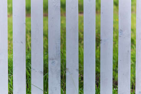 gray wooden fence and a field behind himの写真素材