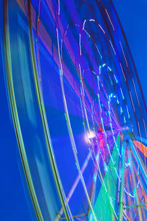 Carnival ride showing a spinning ferris wheel in action- long exposure shot.