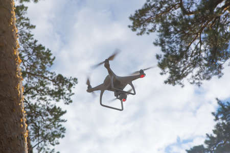 flying drone with camera in blue skyの写真素材