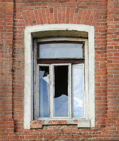 window with broken glass in an old brick wallの写真素材