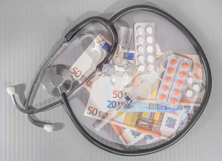 euro banknotes medicines syringe on gray backgroundの写真素材