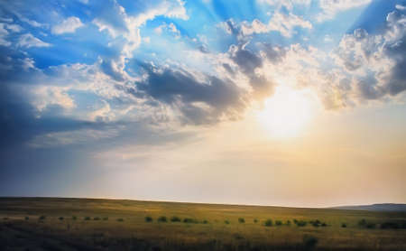 beautiful sunset in cloudy sky over fieldの写真素材