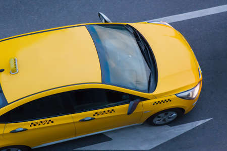 yellow taxi moves on the city street