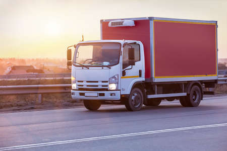 truck goes on highway in evening on sunsetの写真素材