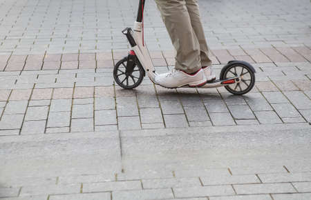 guy riding scooter on granite pavementの写真素材
