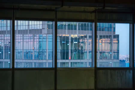 modern skyscraper with glass facade from the window of the building under construction