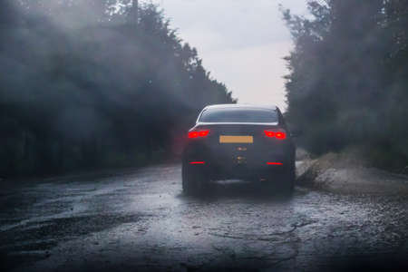 car rides on forest road in downpourの写真素材