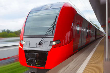 Modern red train approaching the train station