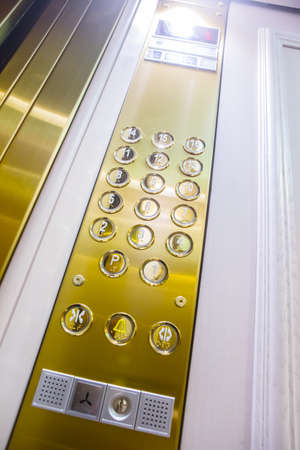 Gilded buttons for selecting floors in the elevator