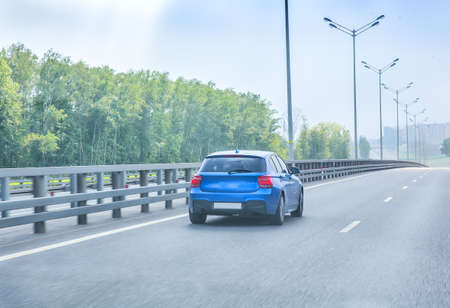 blue car goes on country highwayの写真素材
