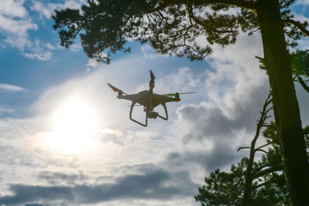 Flying drone with camera in blue sky backgroundの写真素材