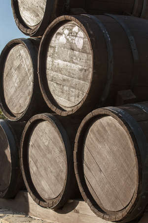 Oak wine barrels in a pile on a pallet.