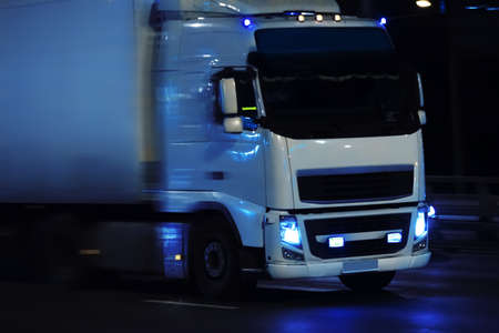 truck moving in rain on night cityの写真素材