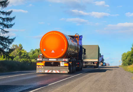 escort of trucks moves on mountain roadの写真素材
