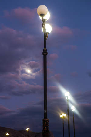Sunset. Electric lamp post against the dark sky.の写真素材