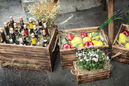 Wine in bottles, apples, pears, flowers in decorative wooden boxesの写真素材
