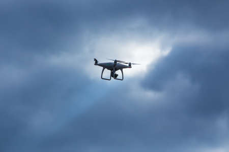 Flying quadcopter with camera in blue skyの写真素材