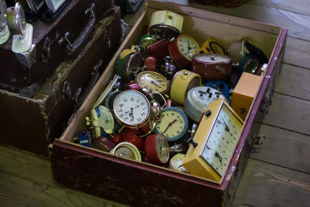 Old mechanical alarm clocks in a wooden boxの写真素材