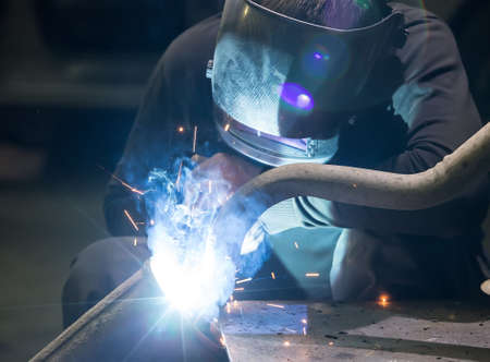 welder in mask welds metal details