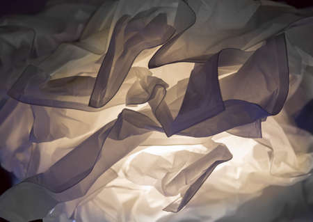 Crumpled paper illuminated from inside. Abstract. Background.