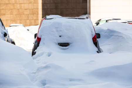 Cars in the parking lot in the winter under the snowの写真素材