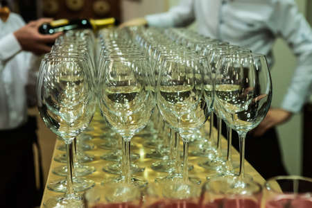 waiters pour champagne on glasses at a banquetの写真素材