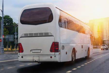 White tourist bus goes on the city streetの写真素材