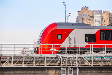 Modern locomotive moves on the railway bridge in the cityの写真素材