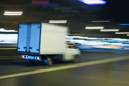 Truck moves on the night avenue at night. Blurred motion.