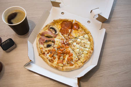 Pizza slices with salami and mushrooms, coffee, drinks on the table in a cafeの写真素材