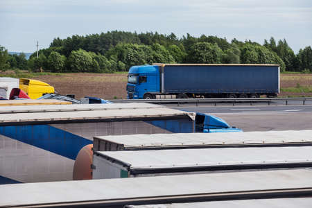 heavy trucks in the Parking lot near the highwayの写真素材
