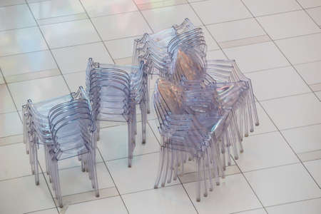lots of plastic transparent chairs on the floorの写真素材