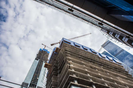 View of multi-storey building under construction and crane in the foreground.の写真素材