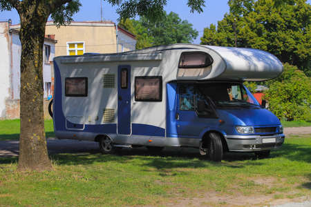 car camping on the grass under a tree near the house