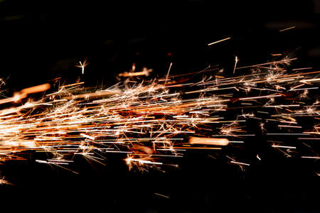 bright sparks of metal against dark backgroundの写真素材