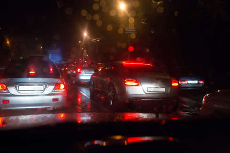 road traffic on a wet city road at night in the rain