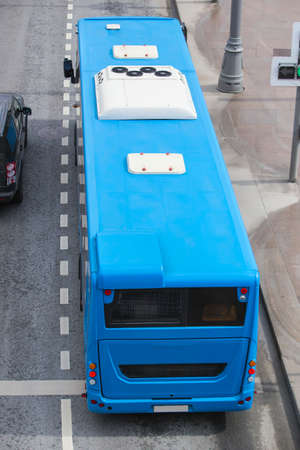Blue city bus on moving road top viewの写真素材