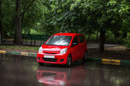 red car parked at the Park in the rainの写真素材