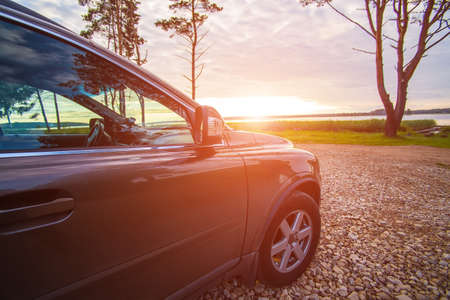car on the lake at sunrise in a cloudy skyの写真素材