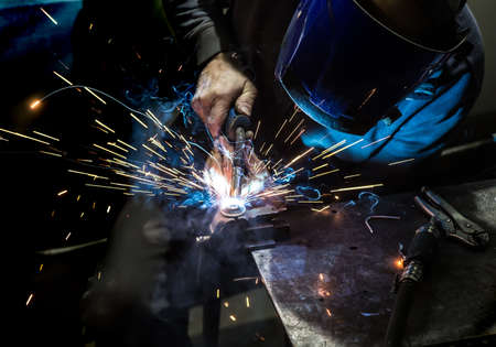 welder in mask welds metal details
