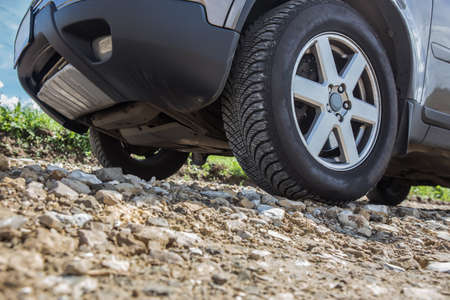 SUV rides on a rocky road. Bottom close-up detail.の写真素材