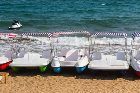 plastic walking boats on a ply sandy sea beachの写真素材