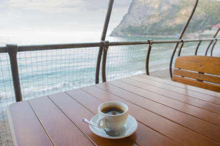 cup of coffee on the table of the summer cafe by the seaの写真素材