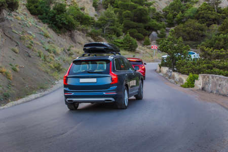 Cars move along a winding mountain road in the mountains.