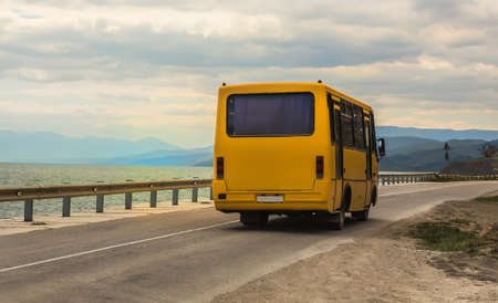 bus moves along the road along the beach