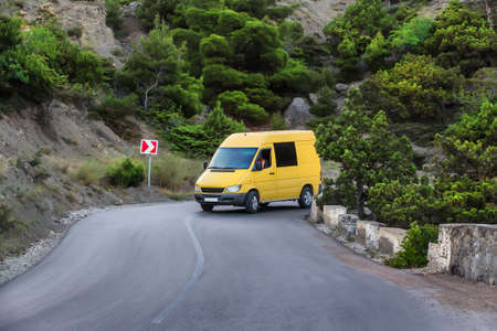 Minibus moves along a winding mountain roadの写真素材