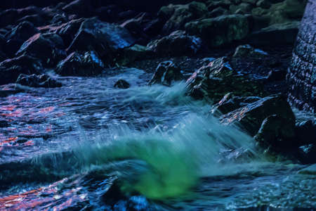 storm on a rocky sea shore at night.の写真素材