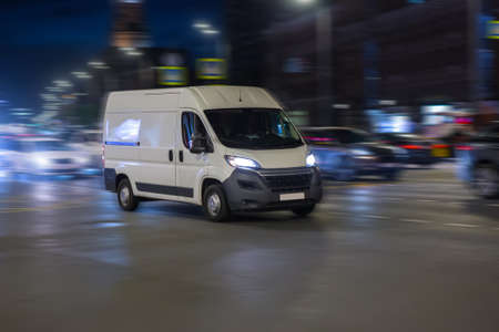 Minibus Moves at Night Along City Ctreetの写真素材